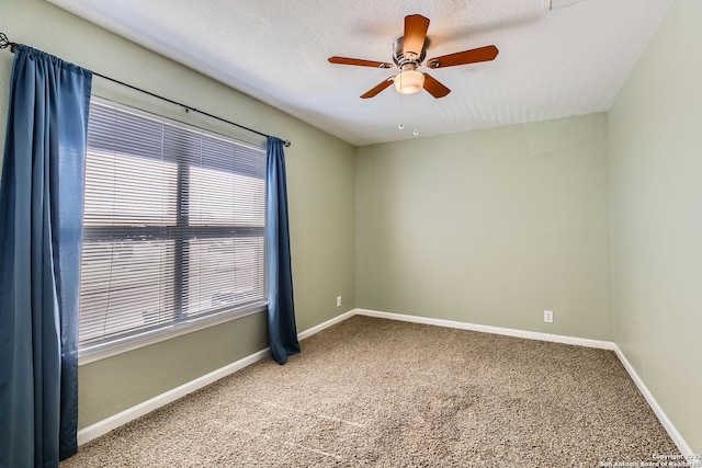spare room with carpet floors, ceiling fan, baseboards, and a textured ceiling
