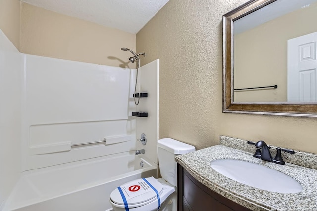 bathroom featuring toilet, a textured wall, tub / shower combination, and vanity
