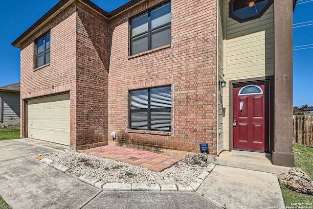 exterior space featuring a garage, brick siding, and driveway