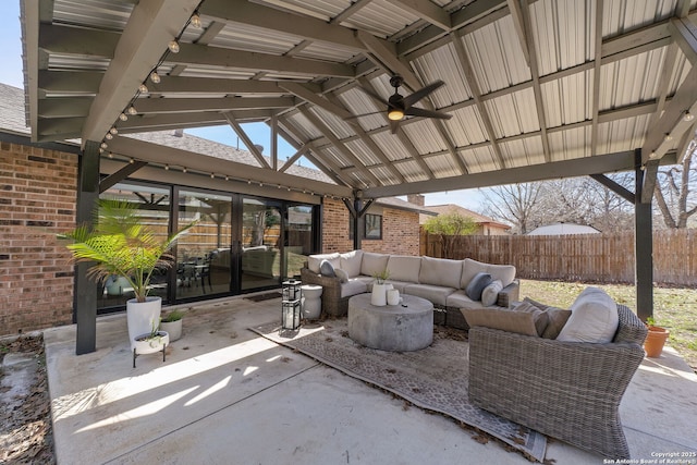 view of patio / terrace featuring fence, an outdoor living space, and a ceiling fan