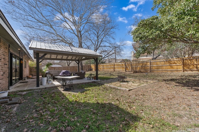 view of yard featuring a gazebo, a fenced backyard, a patio area, and an outdoor living space with a fire pit