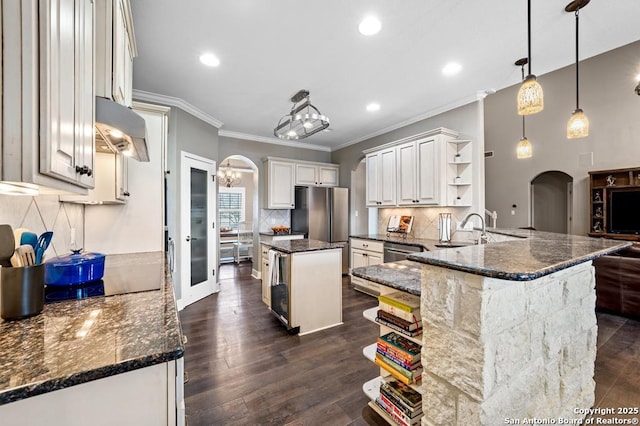 kitchen with arched walkways, dark wood-type flooring, under cabinet range hood, open shelves, and a sink