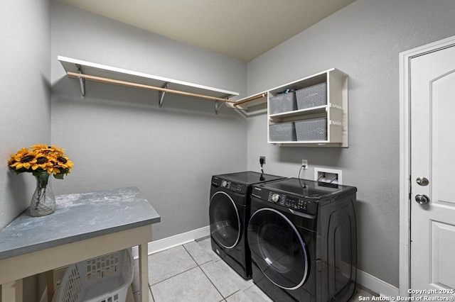 laundry area with light tile patterned floors, laundry area, washer and clothes dryer, and baseboards