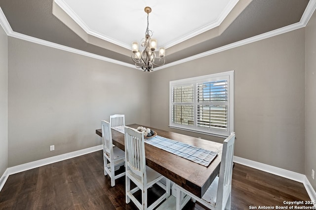 dining room with a chandelier, wood finished floors, a raised ceiling, and baseboards