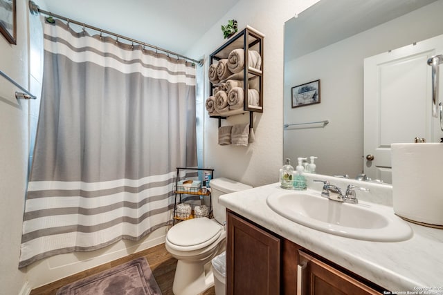 bathroom with vanity, shower / bath combination with curtain, wood finished floors, and toilet