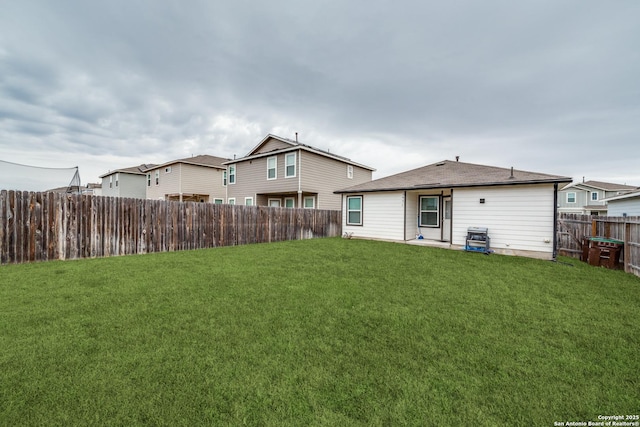 back of property featuring a fenced backyard and a lawn