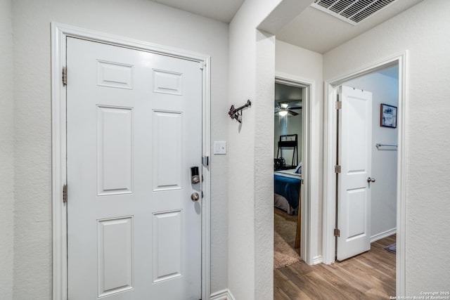 interior space with wood finished floors, visible vents, and baseboards