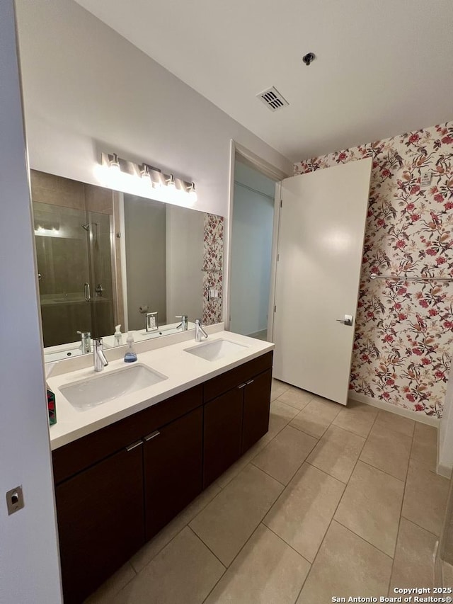 bathroom featuring a stall shower, wallpapered walls, visible vents, and a sink