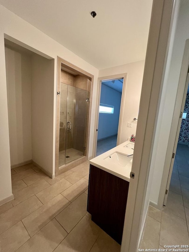 full bathroom with a shower stall, baseboards, and tile patterned flooring