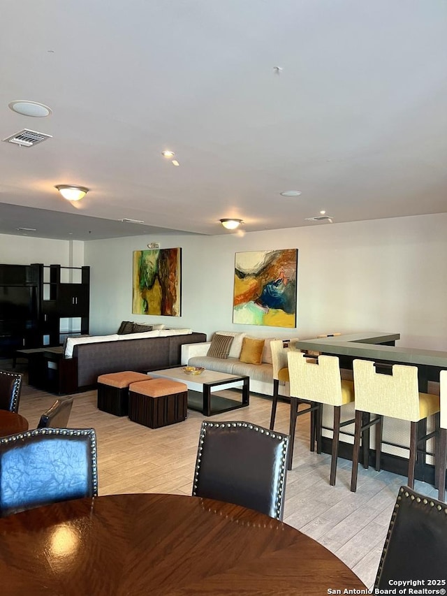 interior space with light wood finished floors, visible vents, and recessed lighting