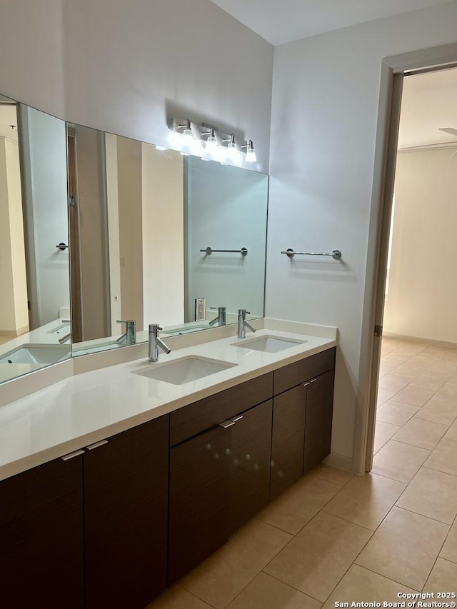 full bathroom with double vanity, a sink, and tile patterned floors