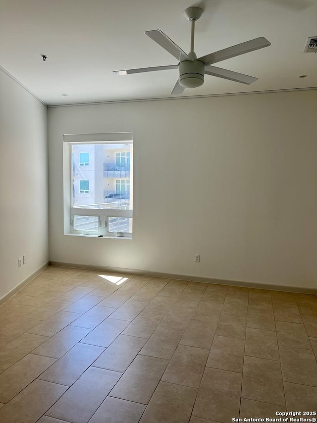 empty room featuring ceiling fan, baseboards, and tile patterned flooring