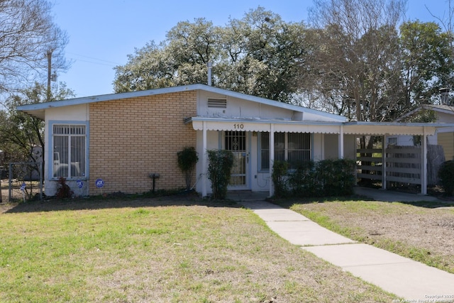 view of front of home with a front lawn and brick siding