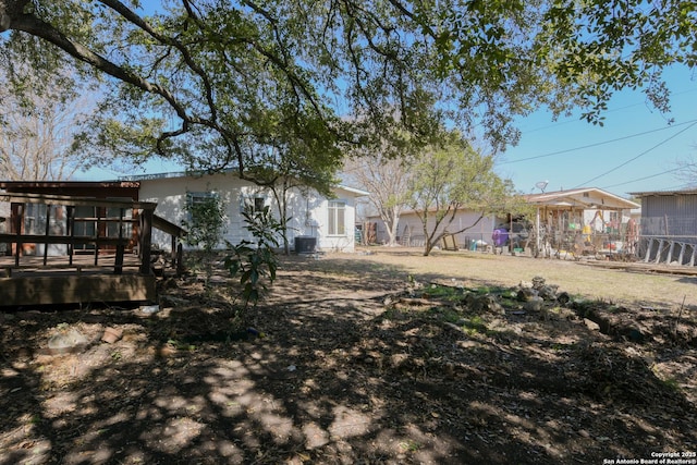 view of yard featuring a wooden deck and fence