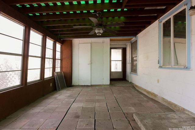 unfurnished sunroom with a ceiling fan