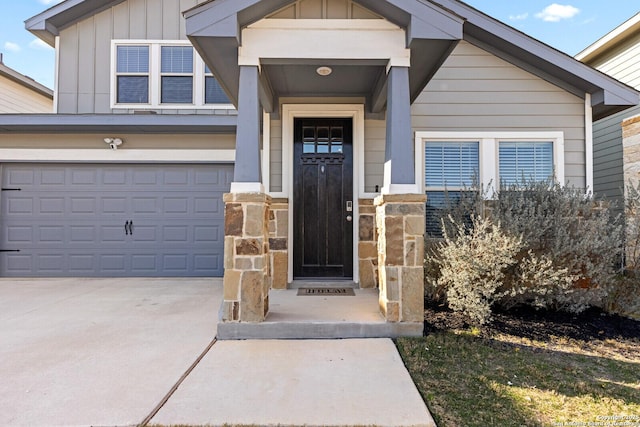 property entrance with concrete driveway, board and batten siding, and stone siding