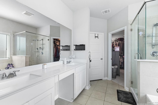 bathroom with a stall shower, visible vents, and a sink