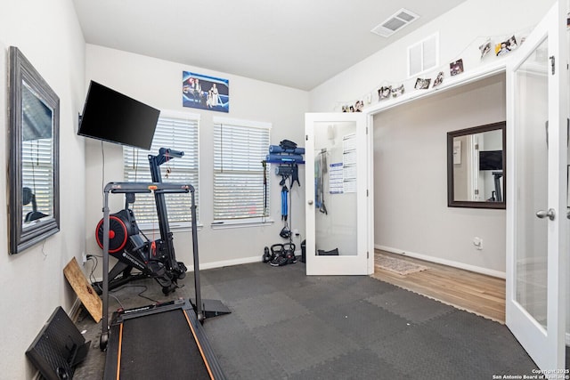 workout room with a healthy amount of sunlight, visible vents, and french doors