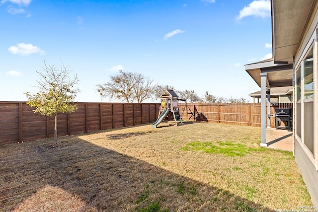 view of yard featuring a playground and a fenced backyard