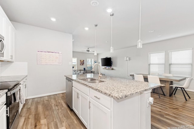 kitchen featuring range with electric stovetop, backsplash, light wood-style flooring, a sink, and dishwasher