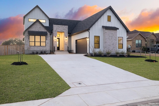 modern farmhouse with a lawn, concrete driveway, an attached garage, fence, and board and batten siding