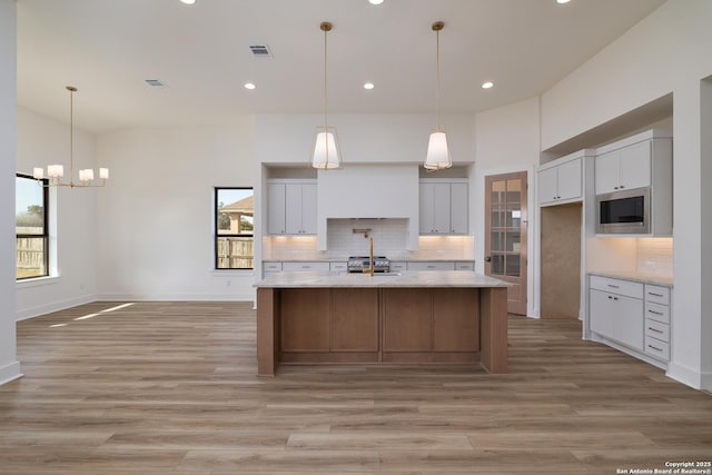 kitchen featuring a wealth of natural light, stainless steel appliances, tasteful backsplash, and a high ceiling