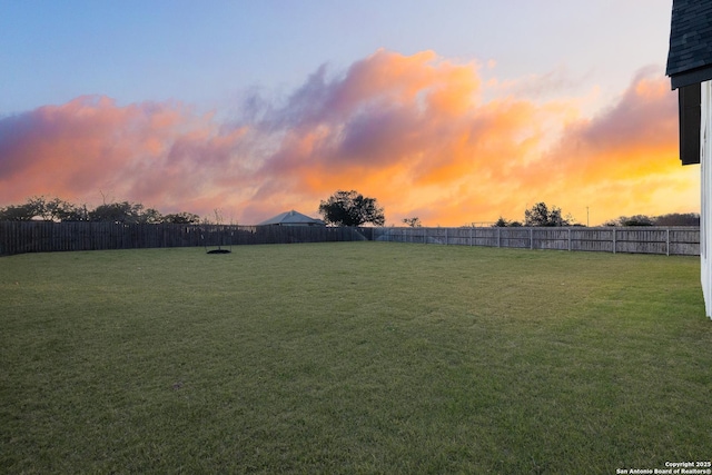 yard at dusk with a fenced backyard