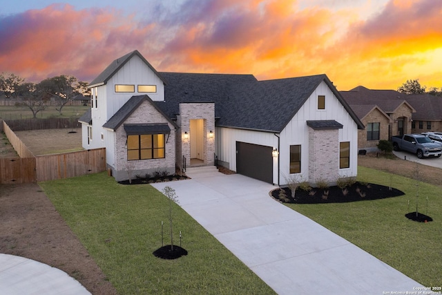 modern farmhouse with a garage, driveway, a front lawn, and fence