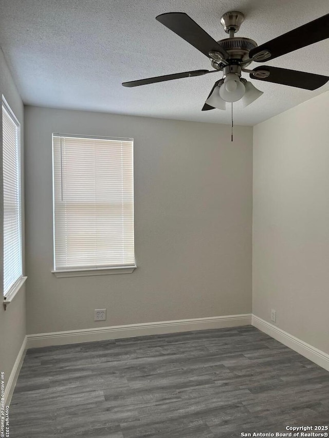 spare room with a textured ceiling, baseboards, and wood finished floors