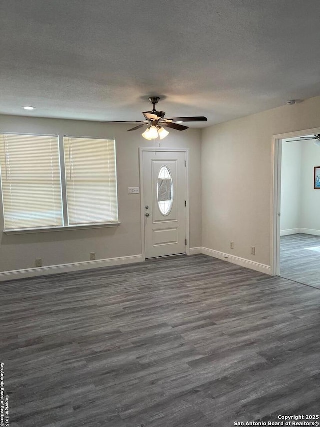 entrance foyer with a textured ceiling, dark wood-style flooring, and baseboards