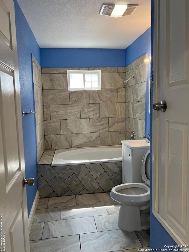 full bathroom with visible vents, tiled shower / bath, toilet, and a textured ceiling