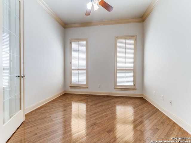 empty room featuring plenty of natural light, light wood-type flooring, and crown molding