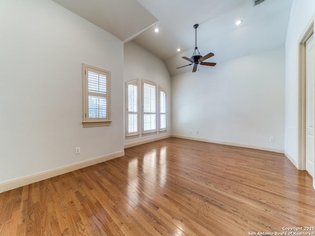 spare room featuring baseboards, a ceiling fan, light wood-style flooring, high vaulted ceiling, and recessed lighting