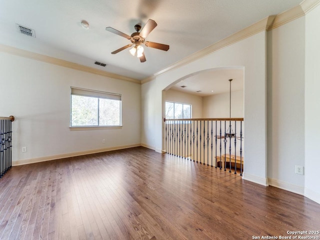 unfurnished room featuring ornamental molding, wood finished floors, and a wealth of natural light