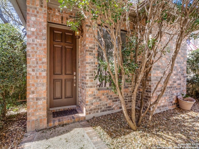 doorway to property with brick siding