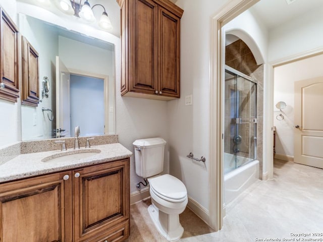 full bathroom with baseboards, combined bath / shower with glass door, vanity, and toilet