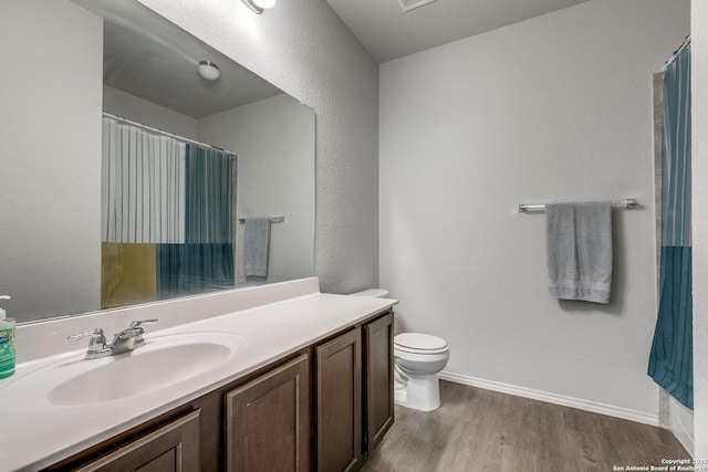 full bath featuring a shower with shower curtain, toilet, vanity, wood finished floors, and baseboards