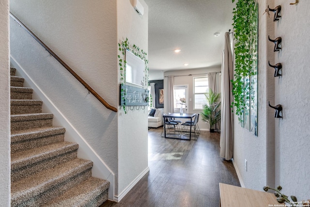 foyer entrance with dark wood finished floors, baseboards, and stairs