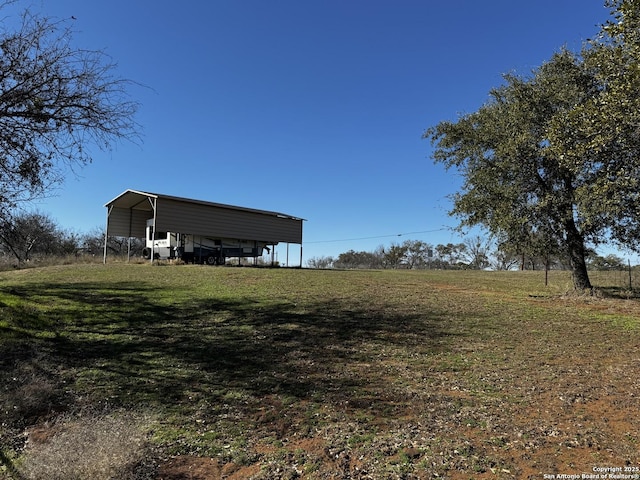 view of yard with a rural view and a detached carport