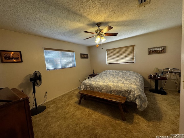 carpeted bedroom with a textured ceiling, baseboards, visible vents, and a ceiling fan