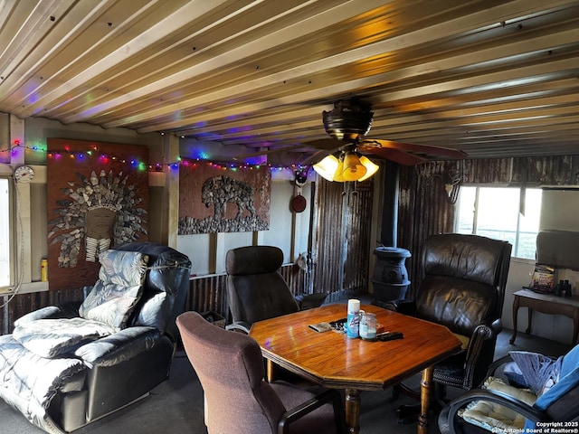 living area featuring a wood stove and a ceiling fan