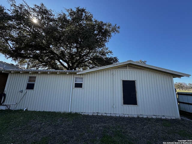 view of side of home featuring metal roof and a lawn