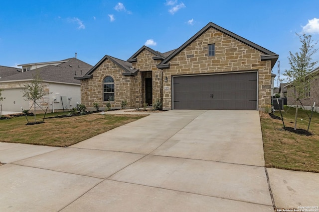 view of front of home with driveway, a garage, and a front yard