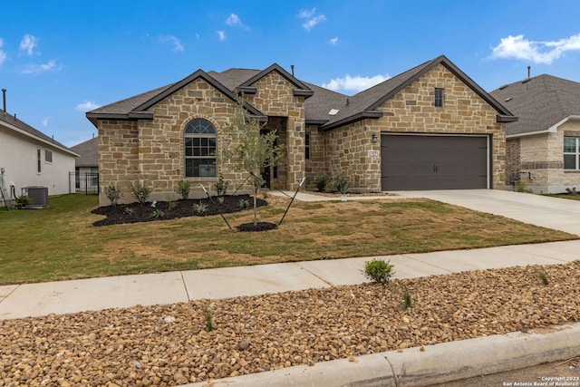 french provincial home featuring a garage, driveway, a front lawn, and central AC unit