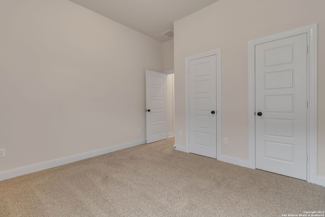 unfurnished bedroom with baseboards, visible vents, and carpet flooring