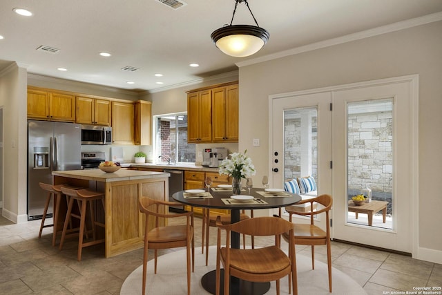 kitchen with a sink, visible vents, light countertops, appliances with stainless steel finishes, and a center island