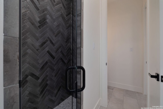 full bathroom featuring a stall shower, baseboards, and tile patterned floors