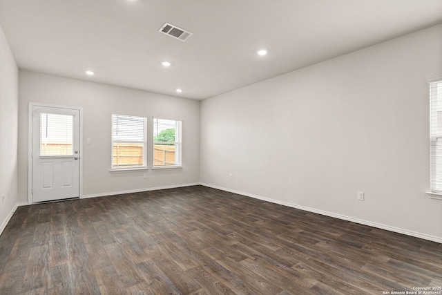 spare room with recessed lighting, visible vents, dark wood finished floors, and baseboards