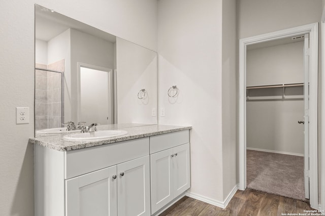 bathroom with baseboards, wood finished floors, and vanity