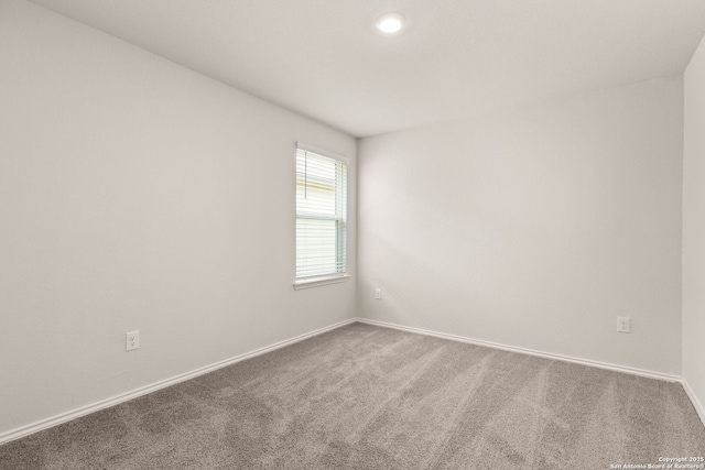 carpeted spare room with baseboards